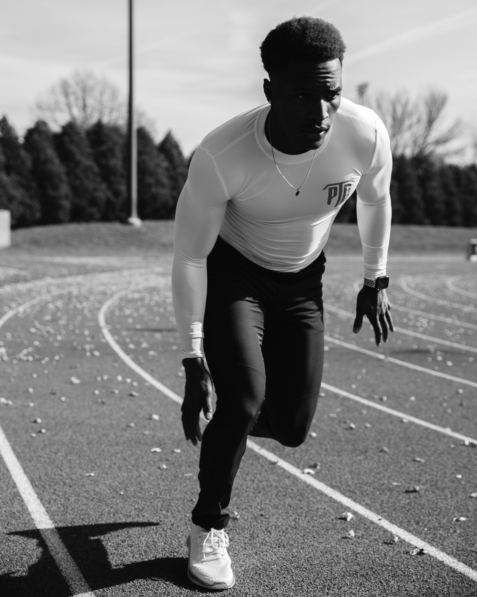 Black and white portrait of Lawrence driving out of a start on the track
